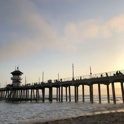 Pier over sea against sky during sunset