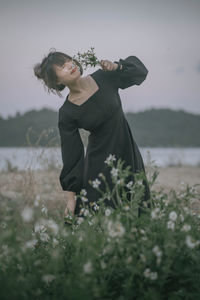 Side view of young woman holding flowers