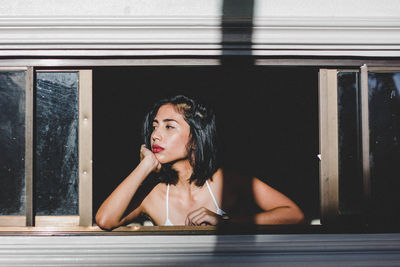 Young woman looking away from travel trailer