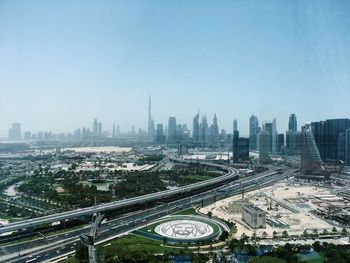 High angle view of highway amidst buildings in city against clear sky