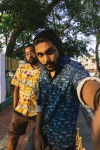 Young couple standing against tree