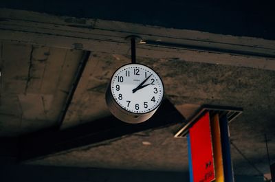 Low angle view of clock mounted on ceiling