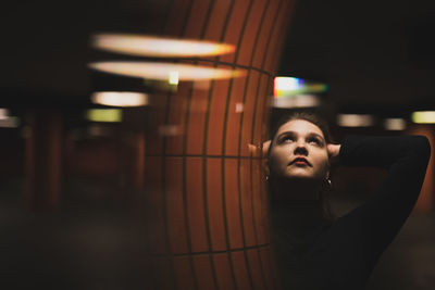 Woman with arms raised standing in illuminated garage