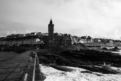 View of buildings in city against cloudy sky