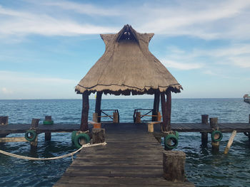 Wooden pier on sea against sky