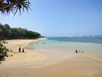 People on beach against sky