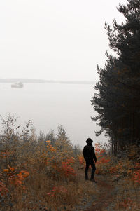 Rear view of man in water against sky