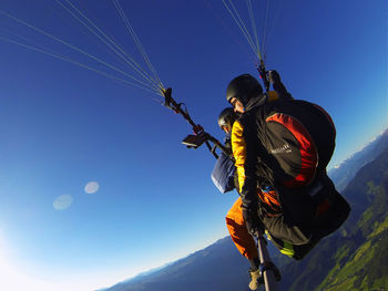 Low angle view of person against clear blue sky