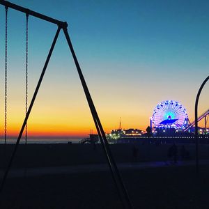 Silhouette ferris wheel against clear sky during sunset