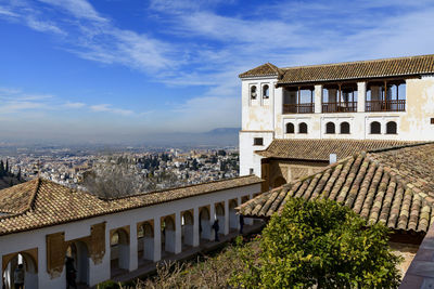 Buildings in town against cloudy sky