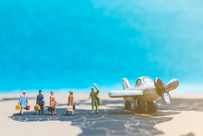 Close-up of toys on beach against blue sky