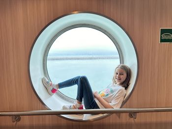Low angle view of young woman standing against wall
