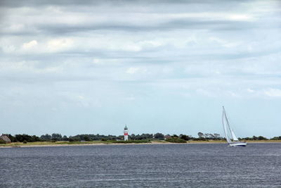 Sailboats sailing on sea against sky