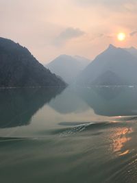 Scenic view of sea and mountains against sky during sunset