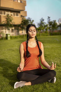 Portrait of young woman sitting on field