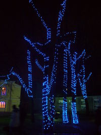 Illuminated christmas lights against sky at night