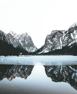 Scenic view of lake by snowcapped mountains against sky