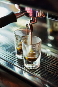 Close-up of espresso maker pouring coffee in glass