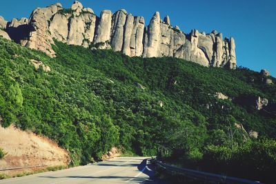Road amidst rocks and trees against sky