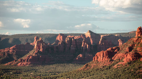 Rock formations on landscape against cloudy sky