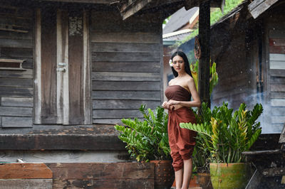 Woman in traditional clothing standing against houses