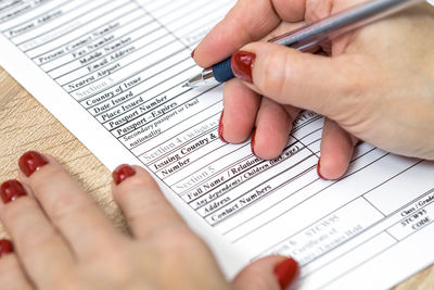 Midsection of woman holding paper