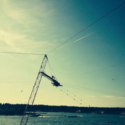 Low angle view of crane against sky