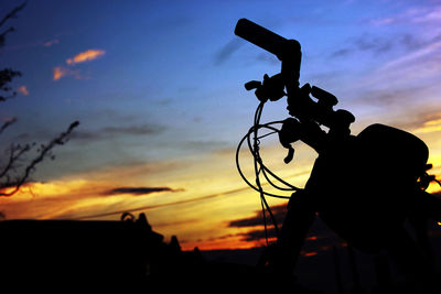 Silhouette man photographing against sky during sunset