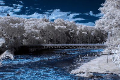 Scenic view of frozen river against sky during winter