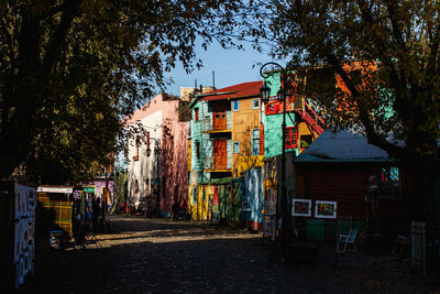 Buildings by street in city against sky