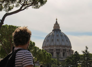 Rear view of a man in front of building