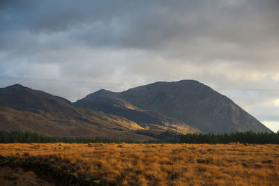 Scenic view of land and mountains against sky