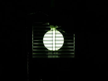 Low angle view of illuminated lamp in dark room