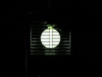 Low angle view of illuminated lamp in dark room