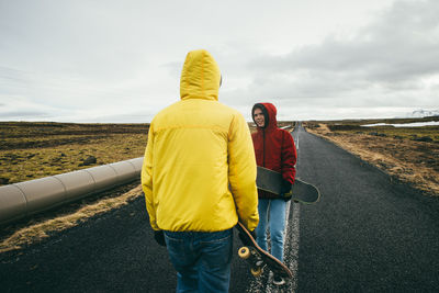 Rear view of two women standing on road