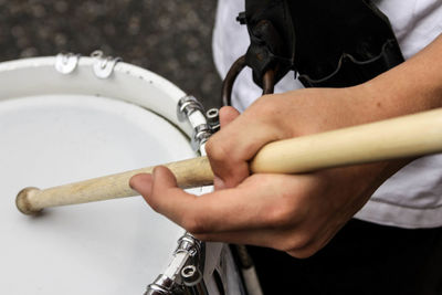 Midsection of man playing drum at music concert