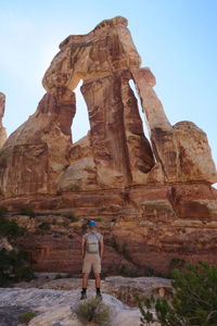 Rear view of woman standing on rock formation