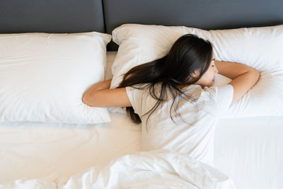 High angle view of woman sleeping on bed at home