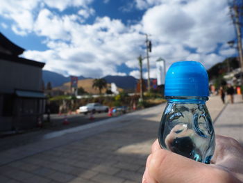 Close-up of hand holding umbrella against sky