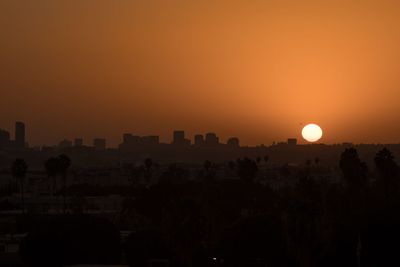 Silhouette buildings against sky during sunset