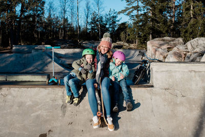Mom playing with her kids at an outdoor skatepark having fun