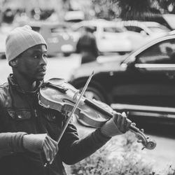 Man playing violin on street in city