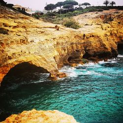 Rock formations by sea against sky