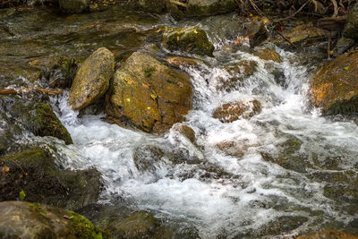 High angle view of stream flowing through rocks