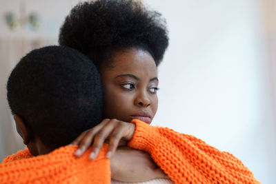 Young african couple man and woman hug embrace after quarrel at home, wife make peace with husband