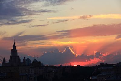 Silhouette of buildings against sky at sunset