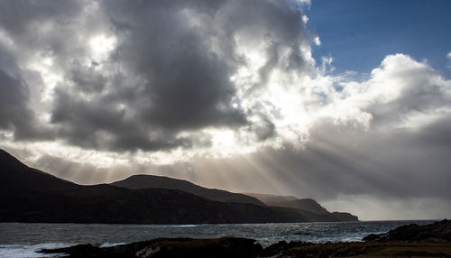 Scenic view of sea and mountains against sky