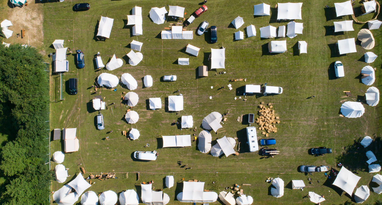 HIGH ANGLE VIEW OF PEOPLE STANDING ON FIELD BY LAWN