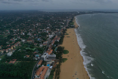 High angle view of townscape by sea against sky