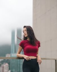 Young woman standing against wall